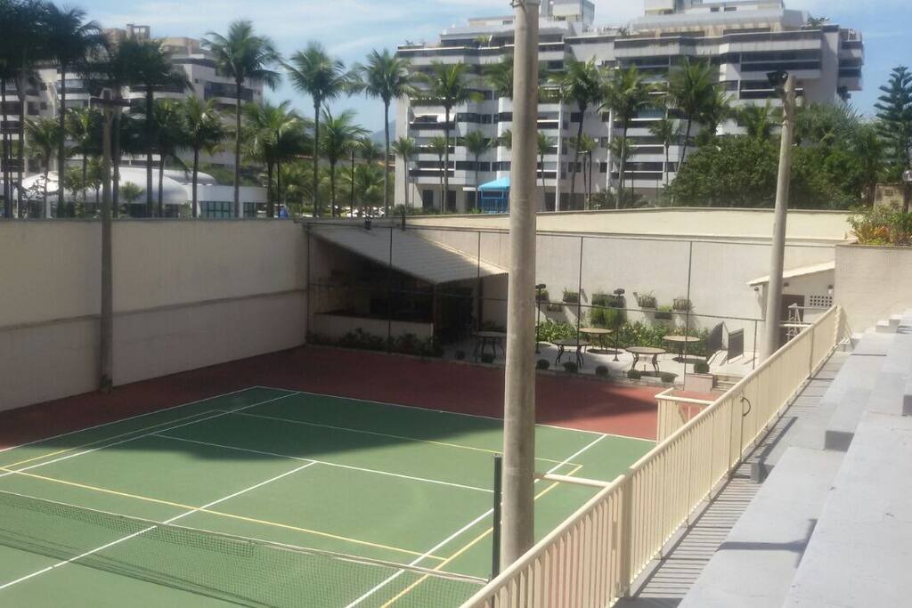 Quadra de tênis e churrasqueira ao fundo