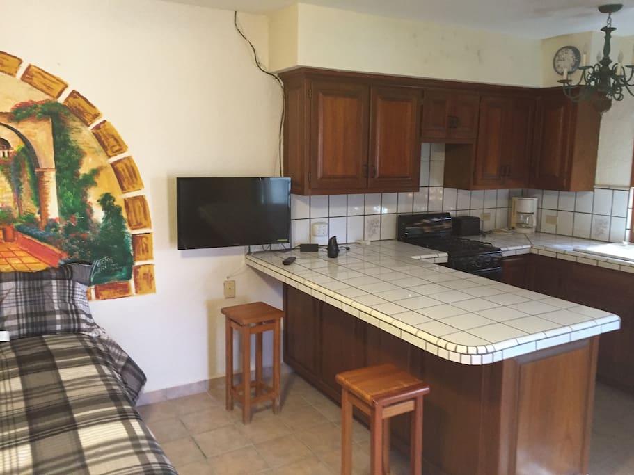 Right side of bed and the kitchen area.
