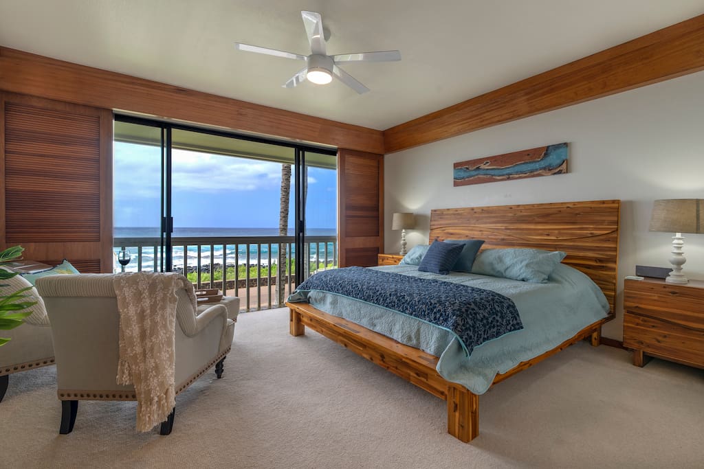 Tranquil master bedroom with doors that open to the ocean and pounding surf.