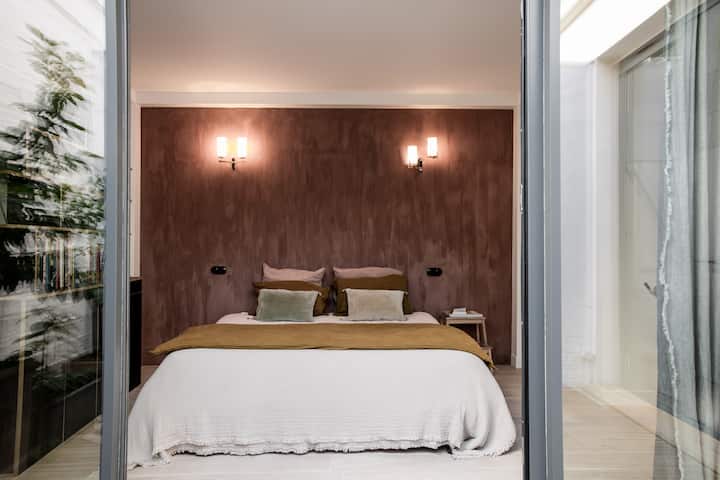 Calme et lumineuse, la suite parentale donne sur un patio arboré.