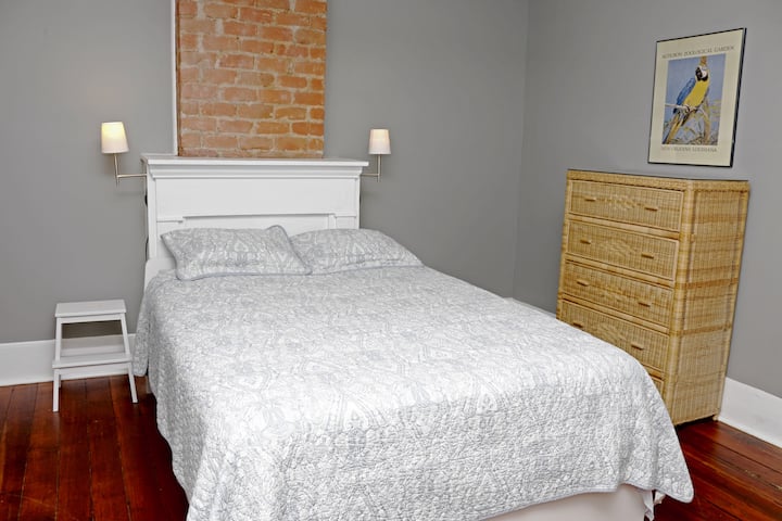 חדר שינה למעלה עם מיטת קווין סייז ליד ארובה ומטלה