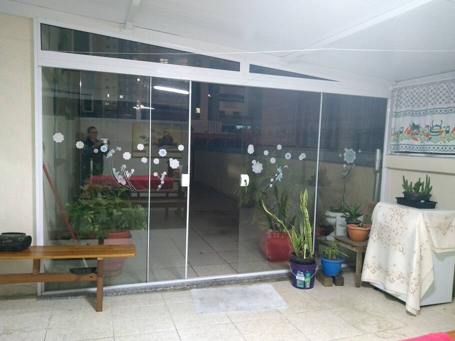 Área externa com mesa e bancos, churrasqueira e espaço para tomar sol. Espaço compartilhado.