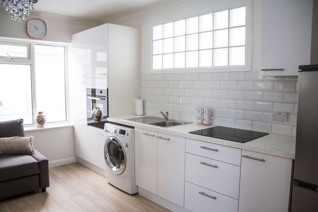 Kitchen area with washer dryer, oven, hob, fridge freezer and microwave (in cupboard).
