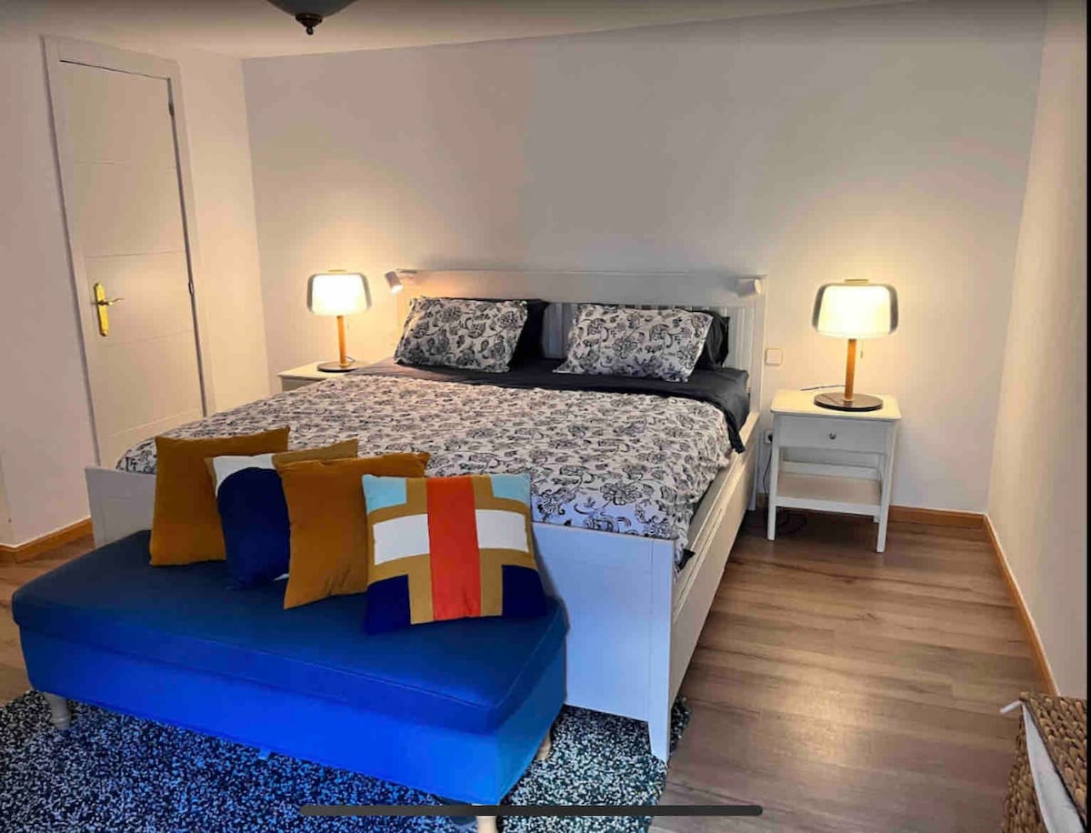 主卧配备加大双人床、空调和步入式衣橱。 窗帘关闭，几乎完全黑暗。 