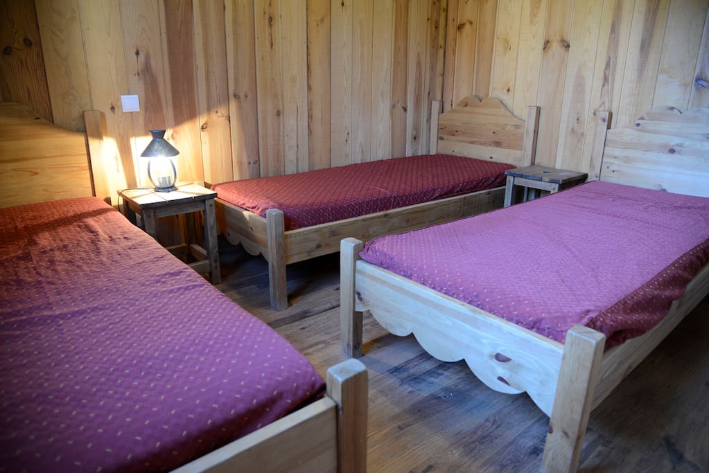 Chambre avec 3 lits simples et salle de bains attenantes