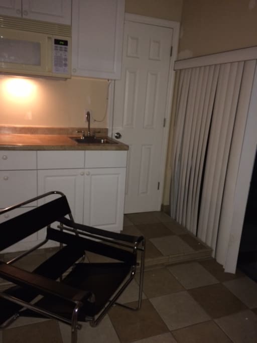 Private sitting area outside private bedroom with wet bar and microwave.