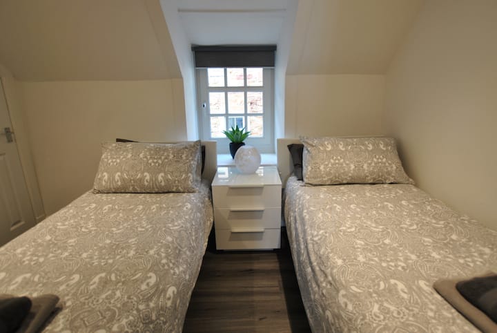 Druhá izba s 2 oddelenými posteľami je na poschodí a má vlastnú kúpeľňu so sprchovacím kútom.