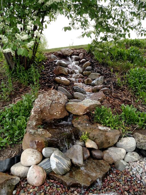 Sit by the firepit and enjoy the sound of the waterfall.