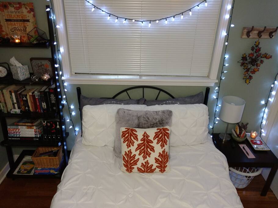 Fall decor, plush bedding, book shelf, end table, romantic lighting.