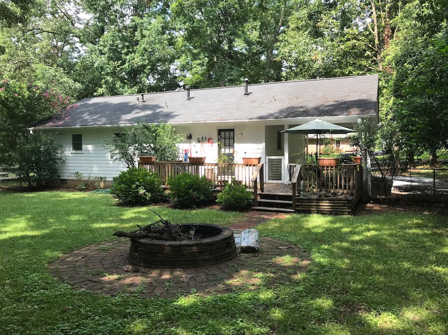 Rear view of home with deck and fire pit. Door in photo enters the kitchen.