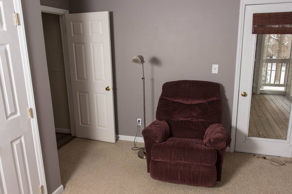 View from the guest bed: Armchair, floor lamp, closet, and access to the back balcony.