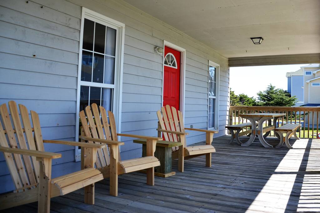 Covered porch with seating and dining overlooking ocean