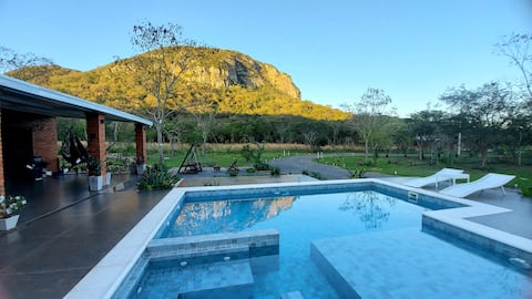 Modern cottage with a pool and a hillside view.