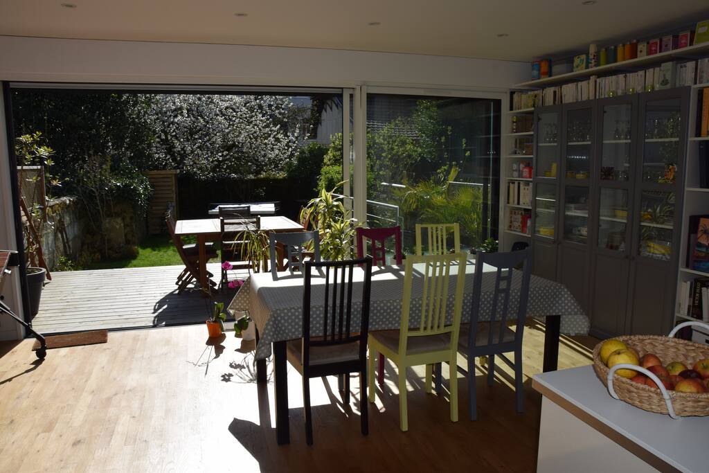 Salle à manger avec baie vitrée 3 vantaux donnant sur terrasse