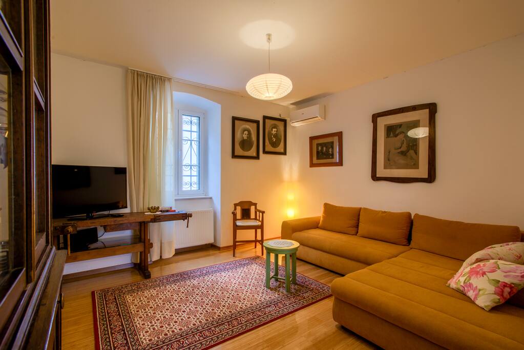 Living room with flat TV and couch-bed.
