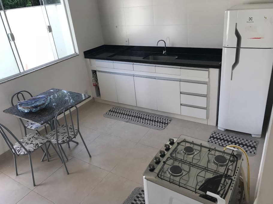 Cozinha com fogão geladeira panelas talheres jarras e utensílios básicos