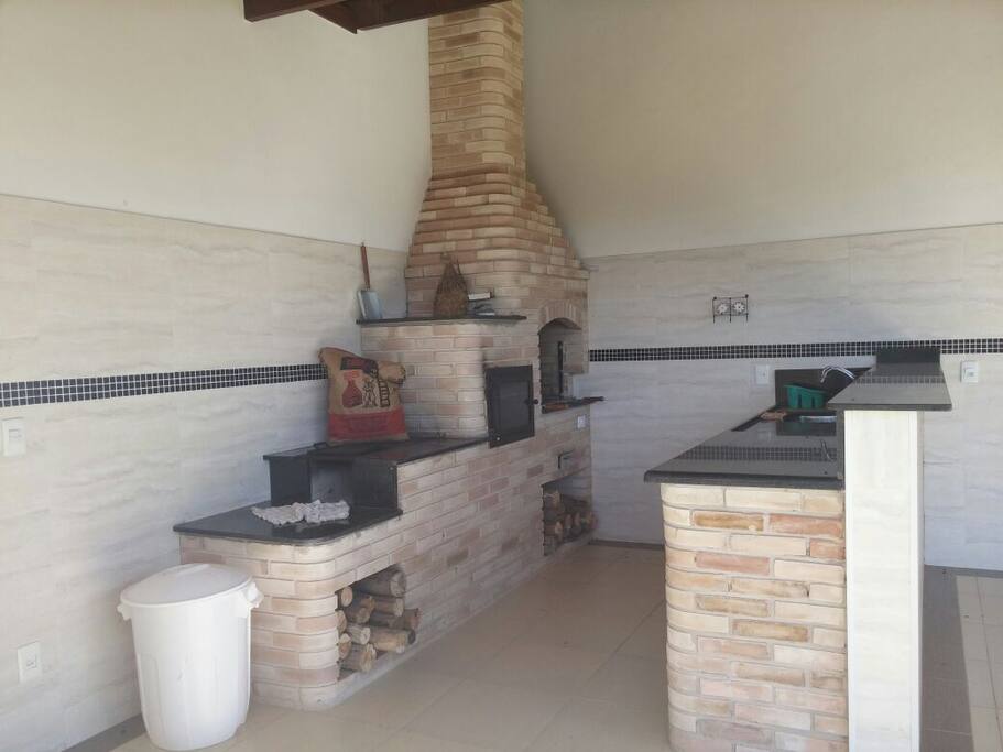 Espaço gourmet com churrasqueira, forno à lenha e fogão caipira
