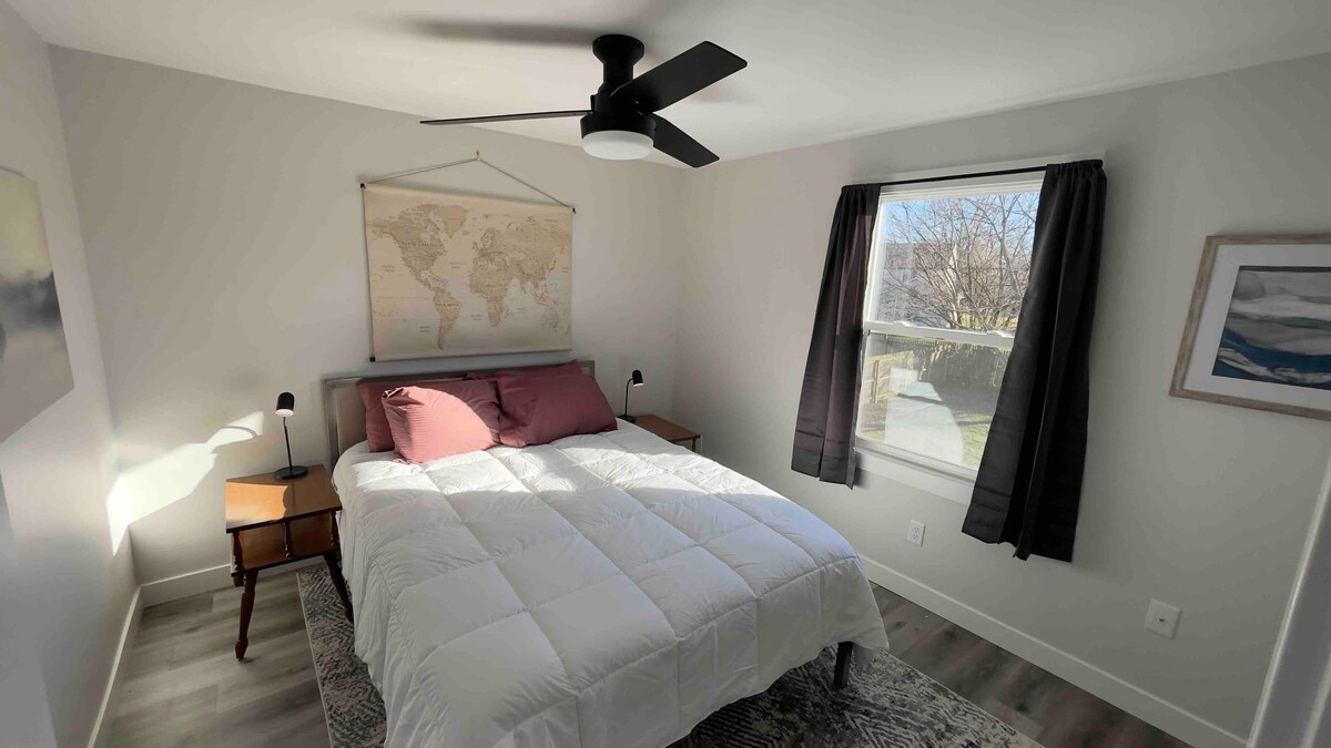 Slaapkamer #3, "hoofdslaapkamer", met nieuw queensize bed, draadloze oplaadlampen, volledige kast en moderne plafondventilator.