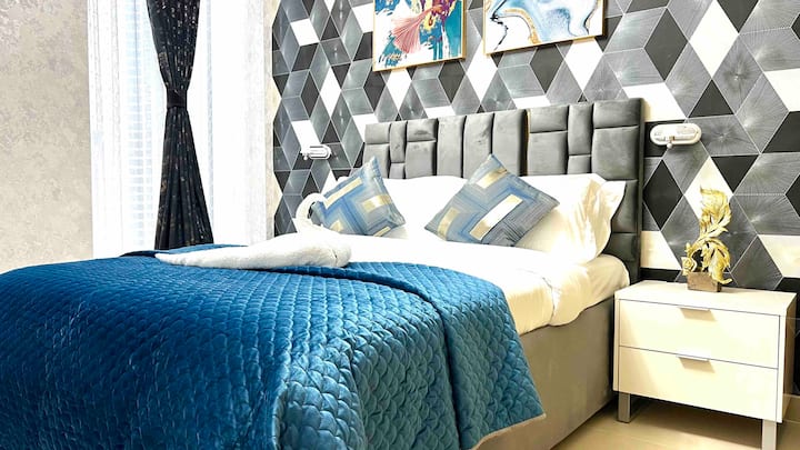 Discover a serene and elegant haven in this beautiful bedroom. Subtle tones and ample windows create a soothing ambiance, while plush bedding and refined artwork offer comfort and sophistication.