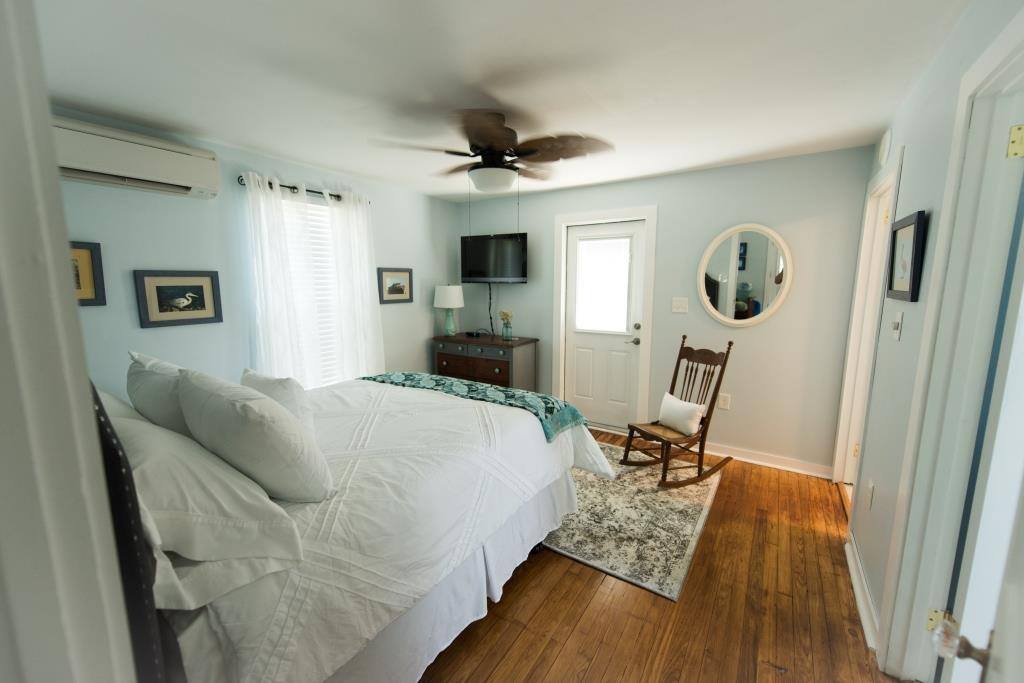 Bedroom viewing TV, chest of drawers and access door to rear deck