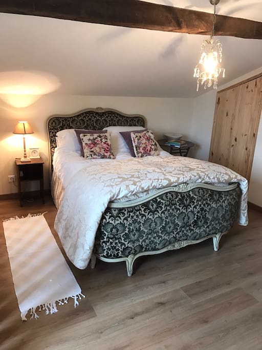 Original antique bed, ancient beams and an exposed stone wall, in the beautifully appointed bedroom.