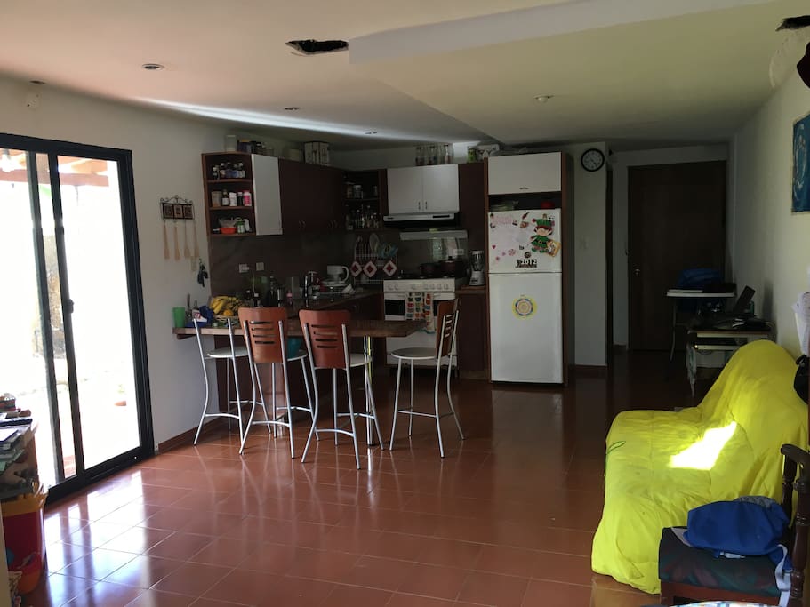 Planta baja: sala, sofá-cama, televisión, cocina, nevera, aire acondicionado, mesón, cuarto de lavandería