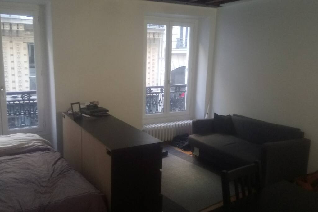Grande chambre privée avec espaces de rangement, canapé et table à manger avec quatre chaise