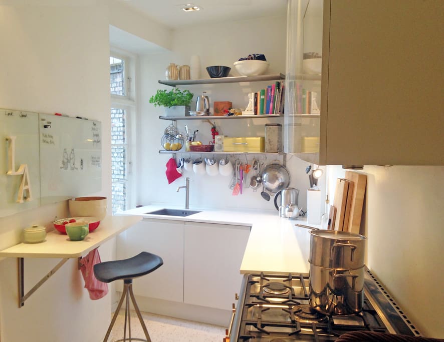 White and modern, yet cosy and colorfull kitchen with a giant SMEG stove & oven
