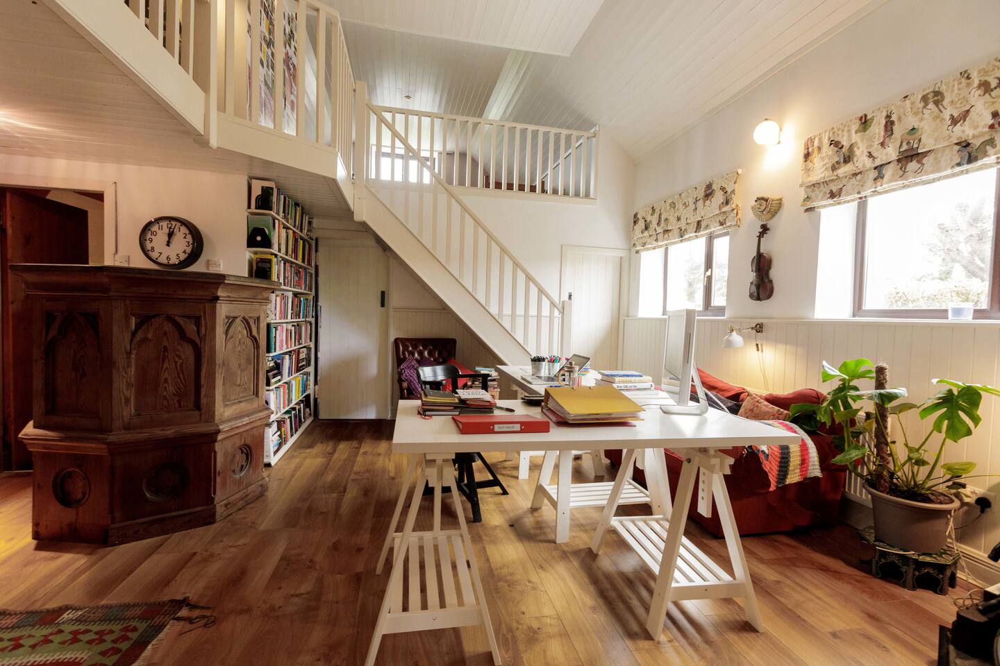 Bright , airy work space/living area with couch and adjustable desks 