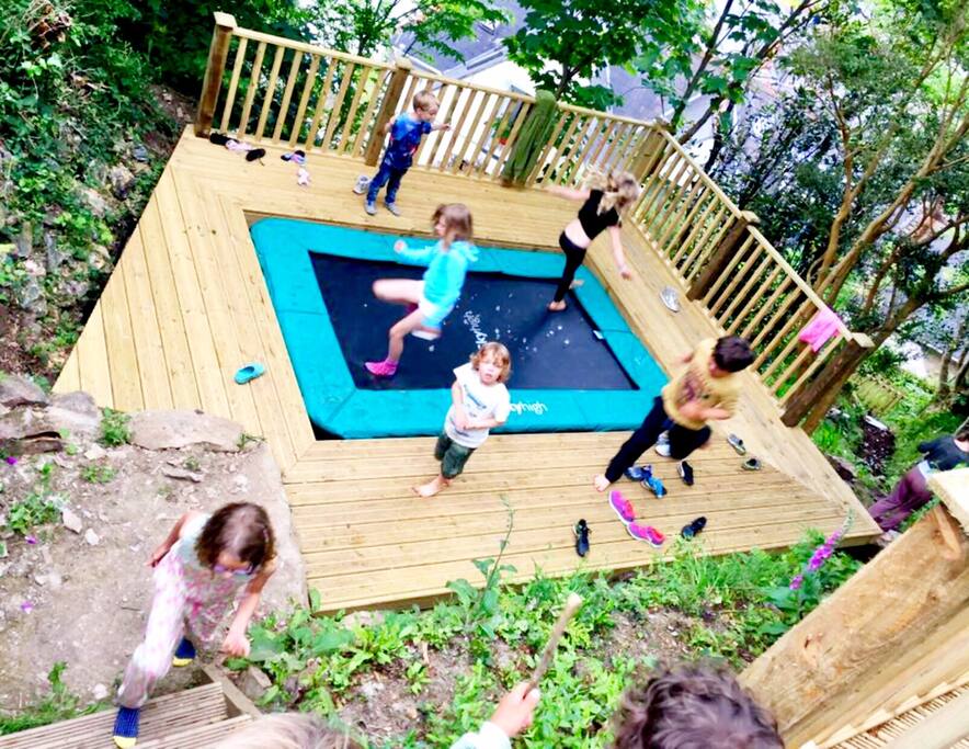 Sunken trampoline on separate level above lower decking/lawn area