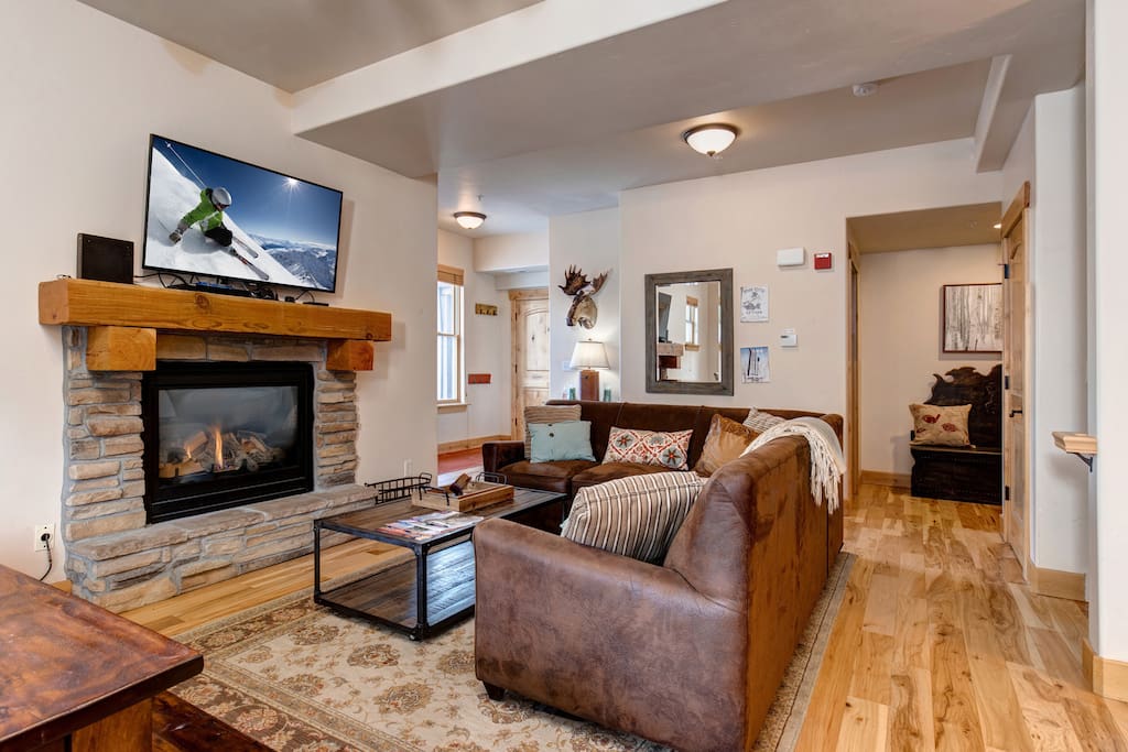 Main living room with sleeper sofa, TV and gas fireplace. 3/4 bathroom and laundry room at this level.