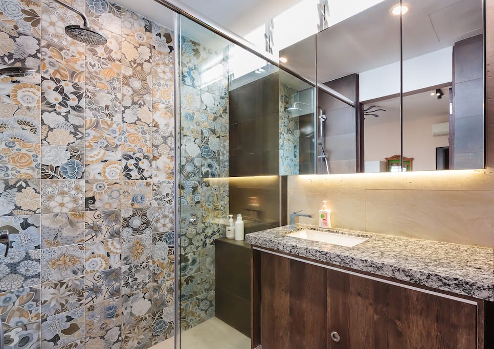 Spacious rainshower (top left) shower area separated and separate granite countertop area, which are separated by glass doors.