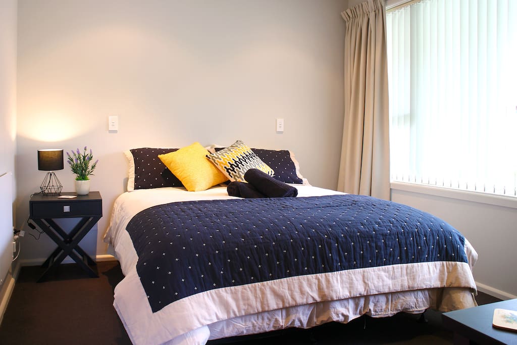 Master bedroom with a queen bed, wardrobe, and fresh towels