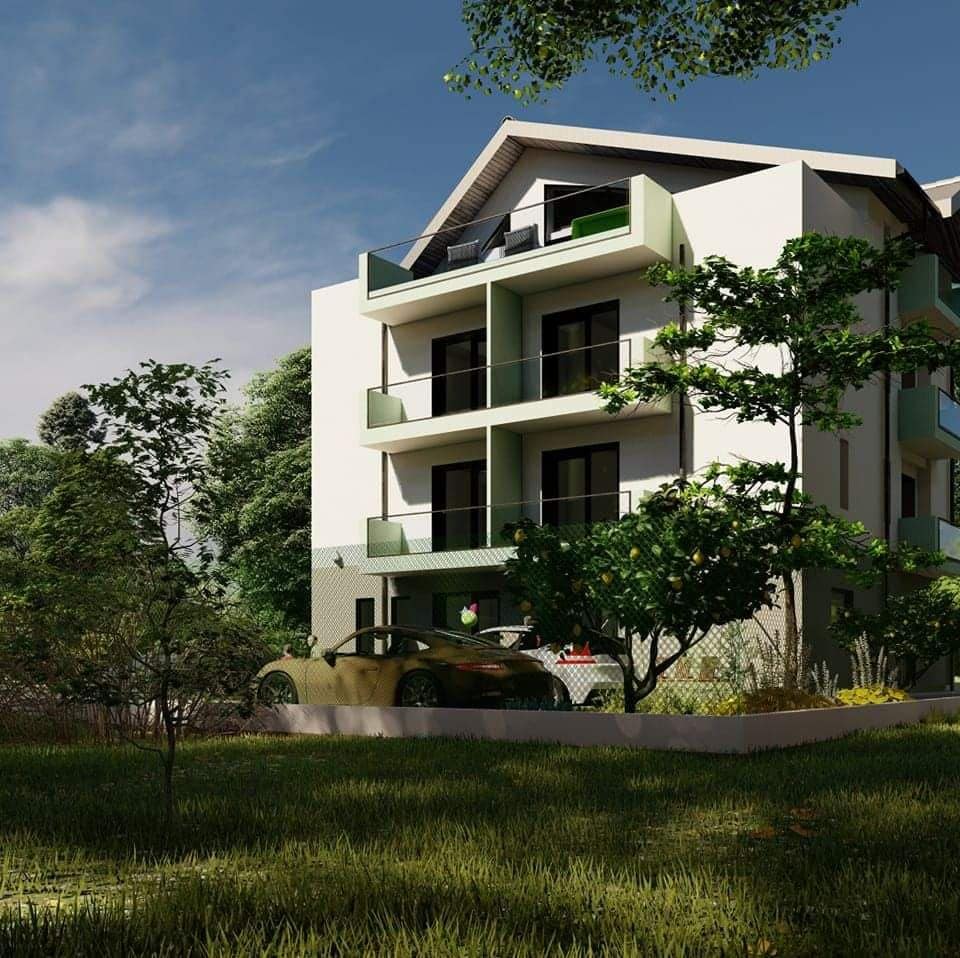 A modern three-story building is surrounded by lush greenery, featuring multiple balconies with sliding doors. A well-maintained garden lays in the foreground, and a vehicle is parked in the driveway, providing easy access to the entrance.