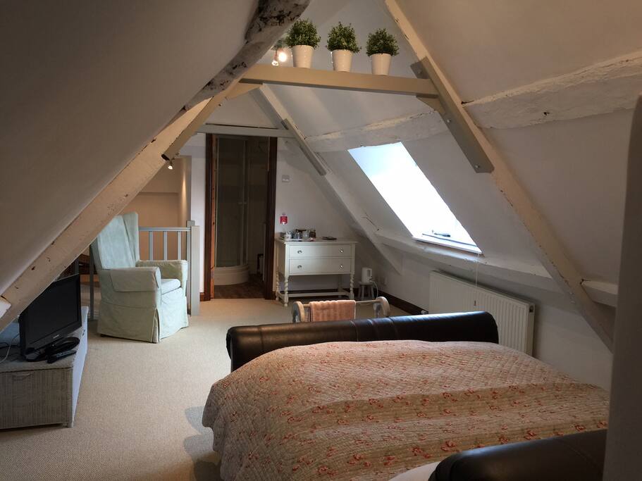 King bed attic room with ensuite at the far end.