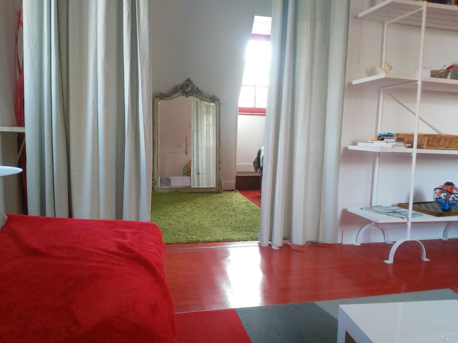 chambre séparée du salon par un rideau