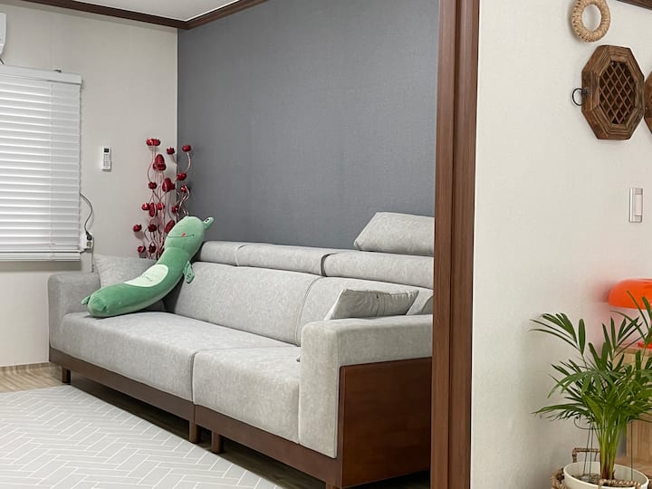 Woonkamer - We hebben een royale bank voor je klaargezet om te ontspannen.