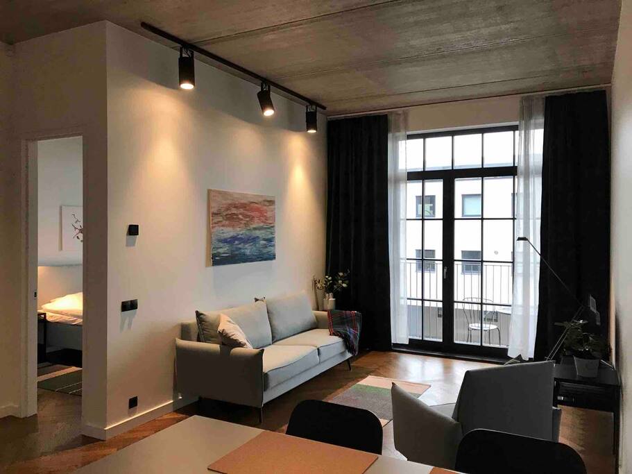 Cozy living room with sofabed to open up. There is also an entrance to the balcony for fresh sea air and table and chairs for morning coffee and breakfast.