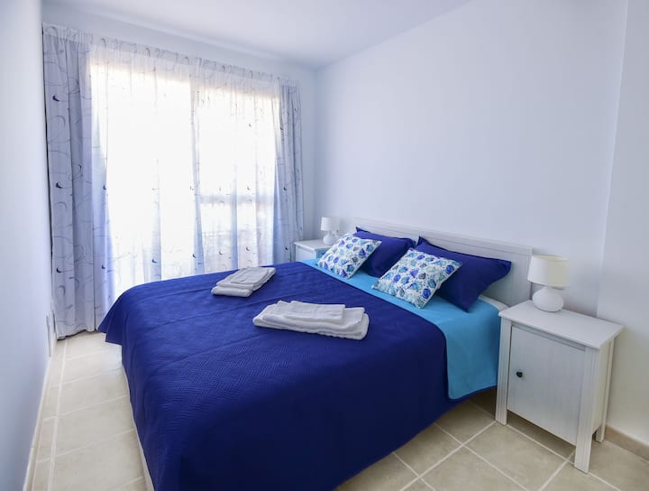 חדר שינה כפול עם גישה למרפסת, שבה אפשר לישון בשלווה, מוקפים בצלילי גלי הים