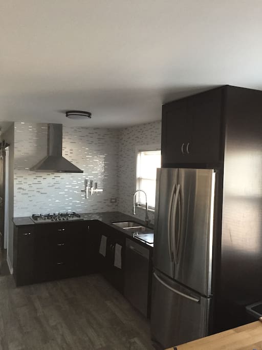 spacious eat in kitchen with stainless steel appliances, granite countertops, lots of cookware