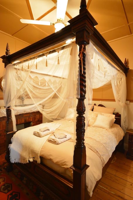 Master bedroom, hand carved four poster bed. Sink into this cozy queen bed and enjoy the atmosphere. Ceiling fan.