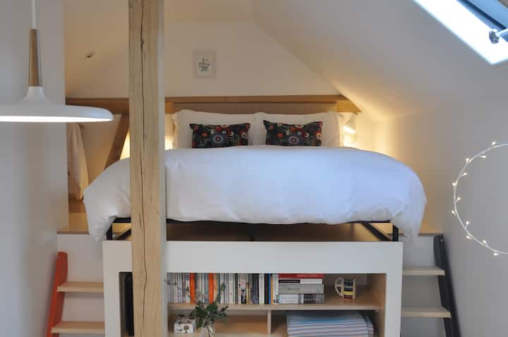 The king sized bed on mezzanine platform with ladder access