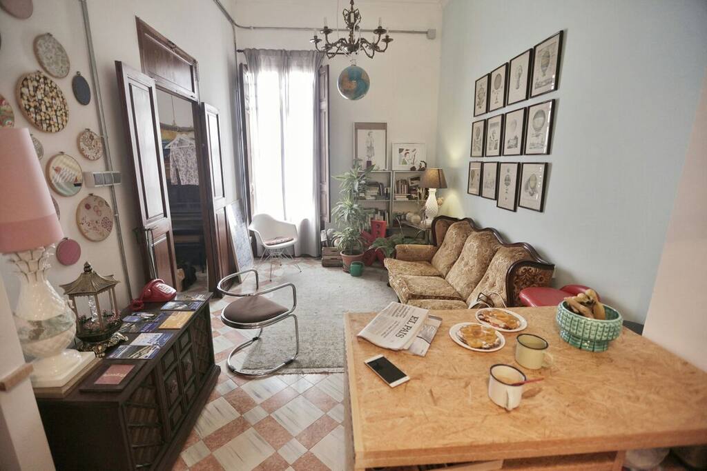 The living room and part of the kitchen. At the left, a table with maps and nrecommendations.