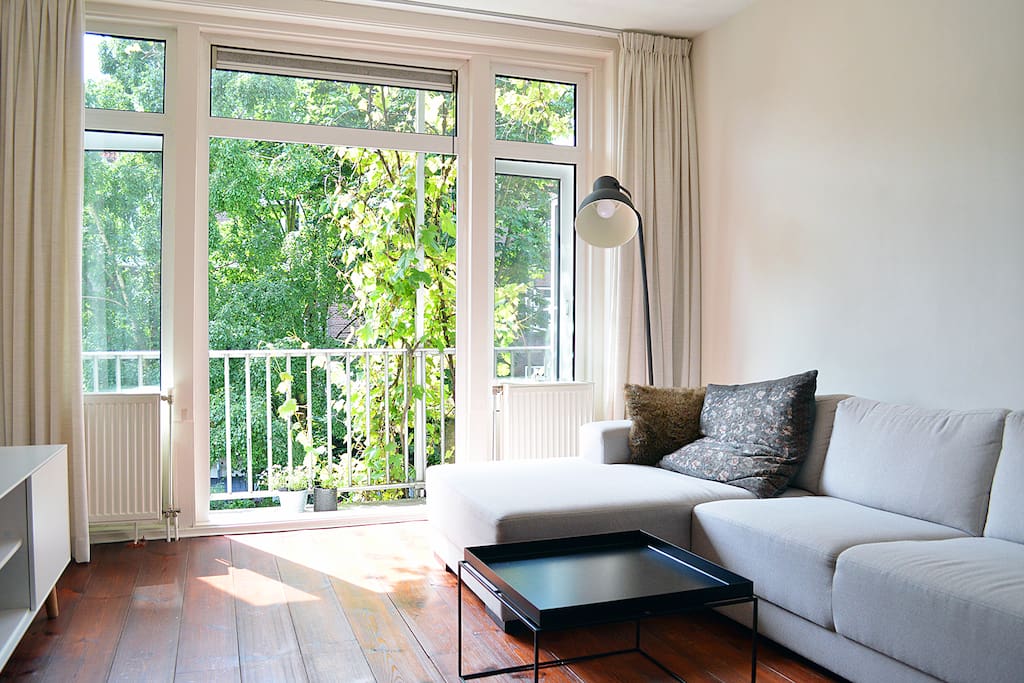 The light living room with the green view from the balcony