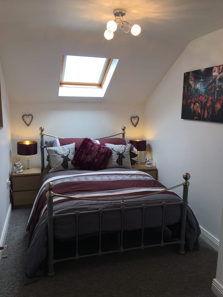 Bedroom 2 - ‘Clarke’

Grey double bed frame. Stylish aubergine and grey comforter set and feature cushions. 
Ample hanging and storage space. Wall mounted flat screen HD smart TV. 