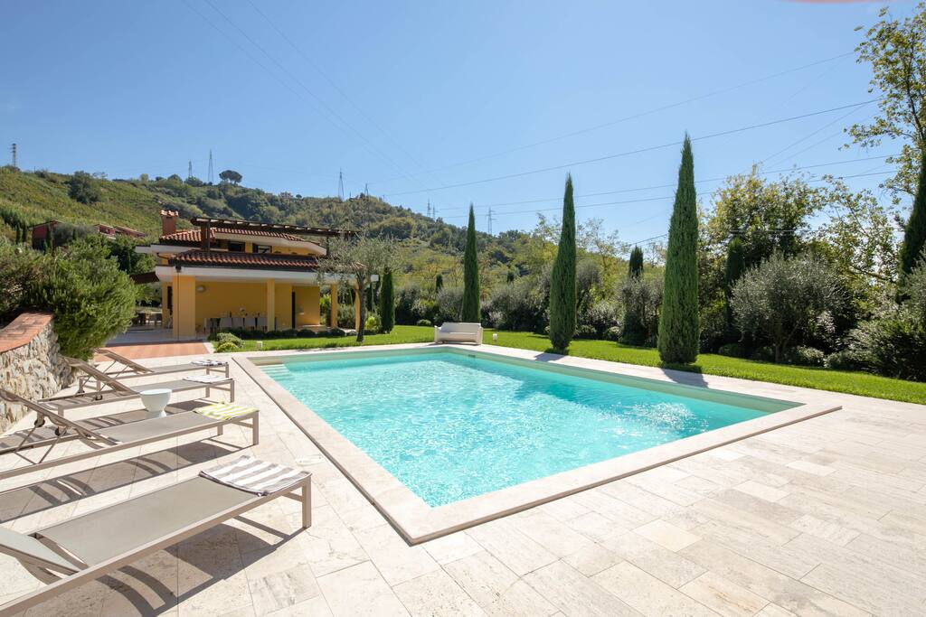 the private swimming pool surrounded by sunbeds, beach umbrellas and outdoor shower