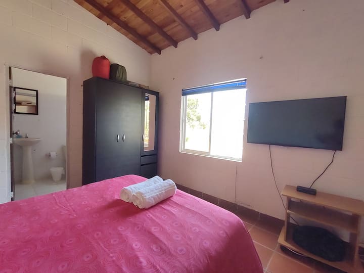 Cuarto principal con baño privado y cama doble.