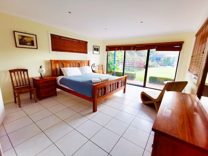 Suite principal en la planta baja con cama king, baño privado, vistas al mar y acceso directo a los jardines.