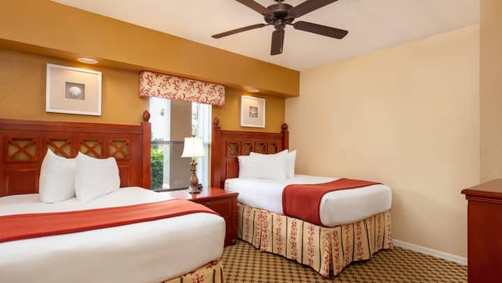 Deze slaapkamer is voorzien van twee tweepersoonsbedden of een queensize bed, afhankelijk van de configuratie van de suite.
Dressoir en kastruimte voor opslag.
TV en extra zitplaatsen, waardoor het een gezellige ruimte is voor gasten.
