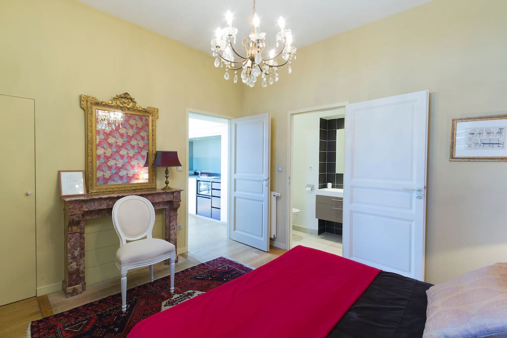 La Jacques Brel bedroom with access to kitchen area (left) and access to bathroom (right)